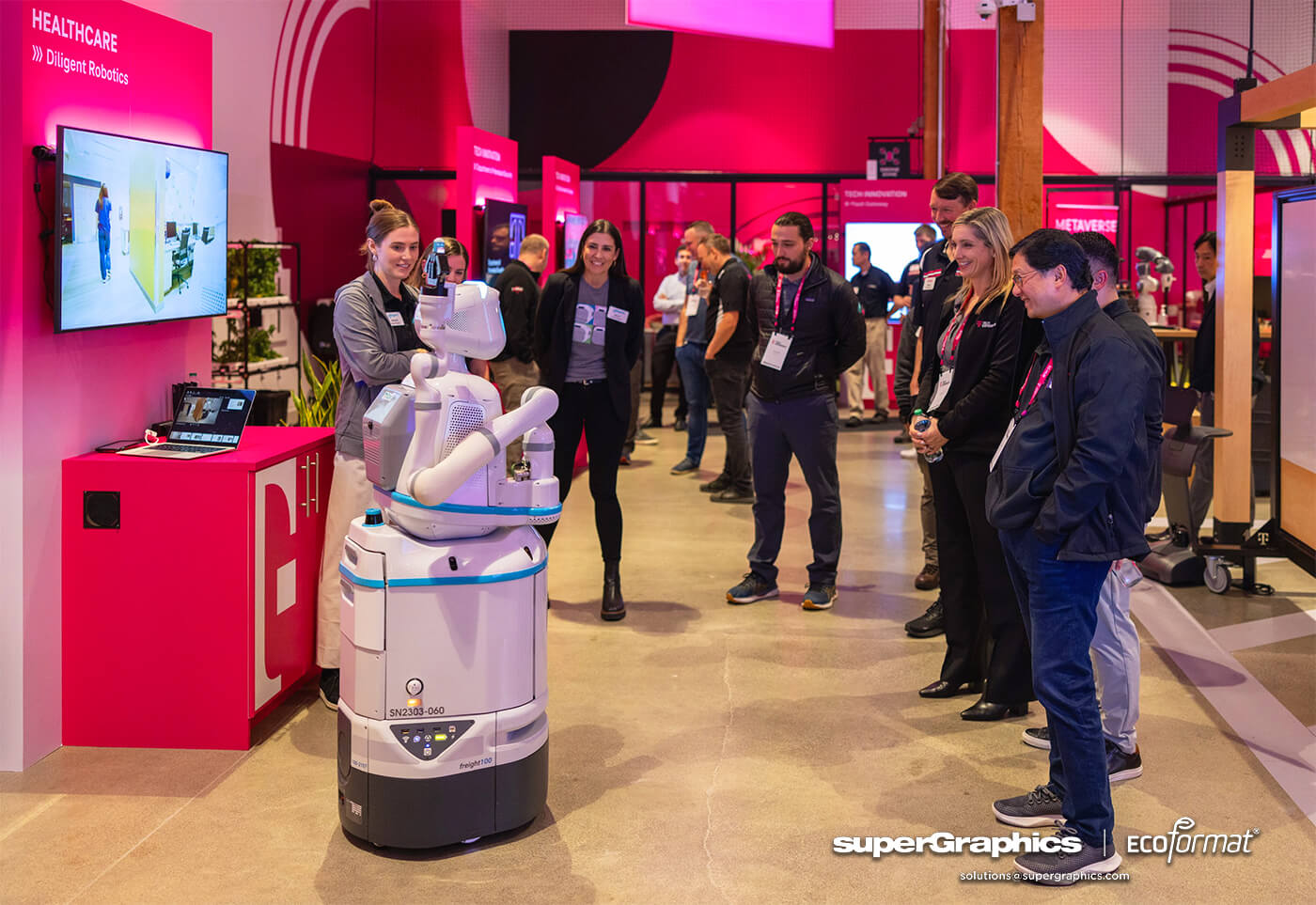 A robot display at a T-Mobile event with vibrant pink branding and interactive screens.
