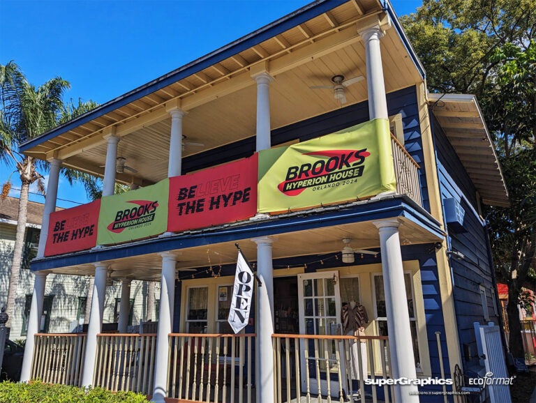 A blue two-story building with large banners promoting Brooks Hyperion House and the slogan "Believe the Hype."