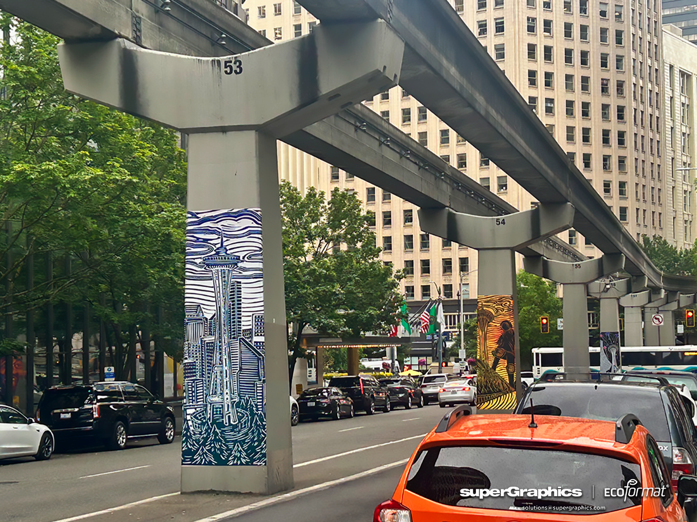 Seattle monorail columns wrapped in various vibrant graphics, including the Space Needle and cityscapes.