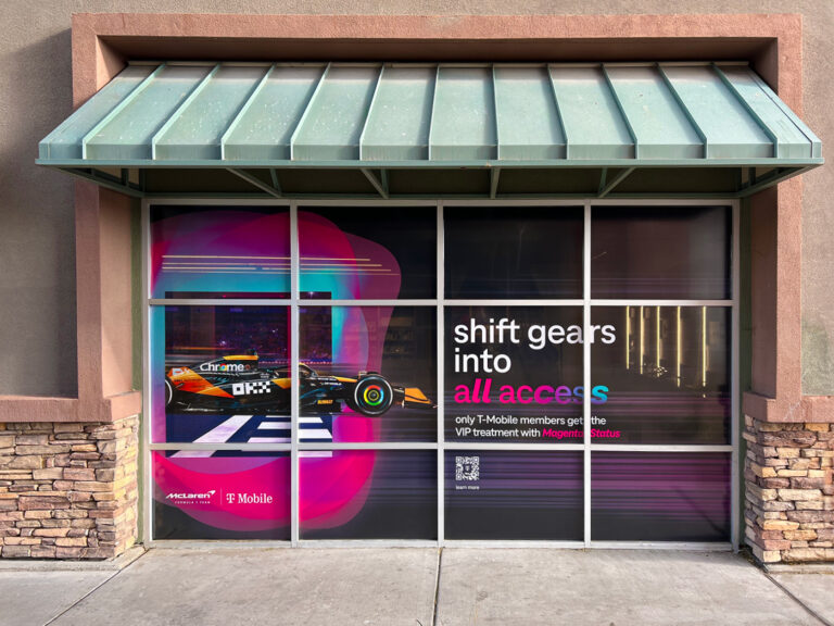 Retail window display featuring a Formula 1 car graphic and corporate branding elements.