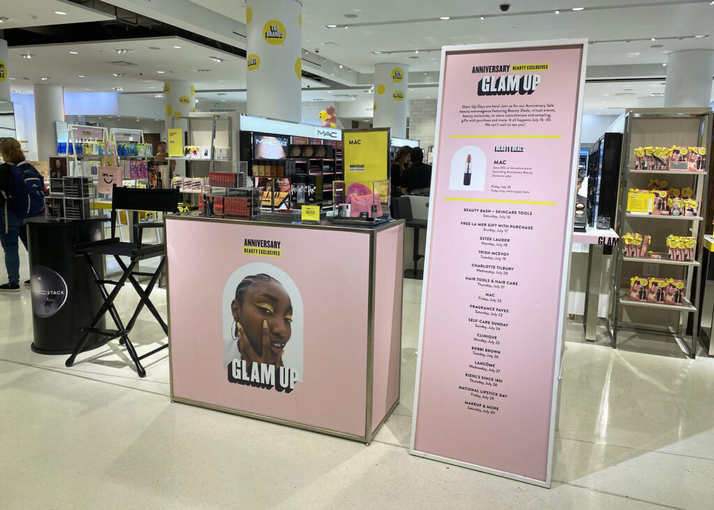 Nordstrom Anniversary signage, produced by SuperGraphics. Showcases pink sale displays with product details.