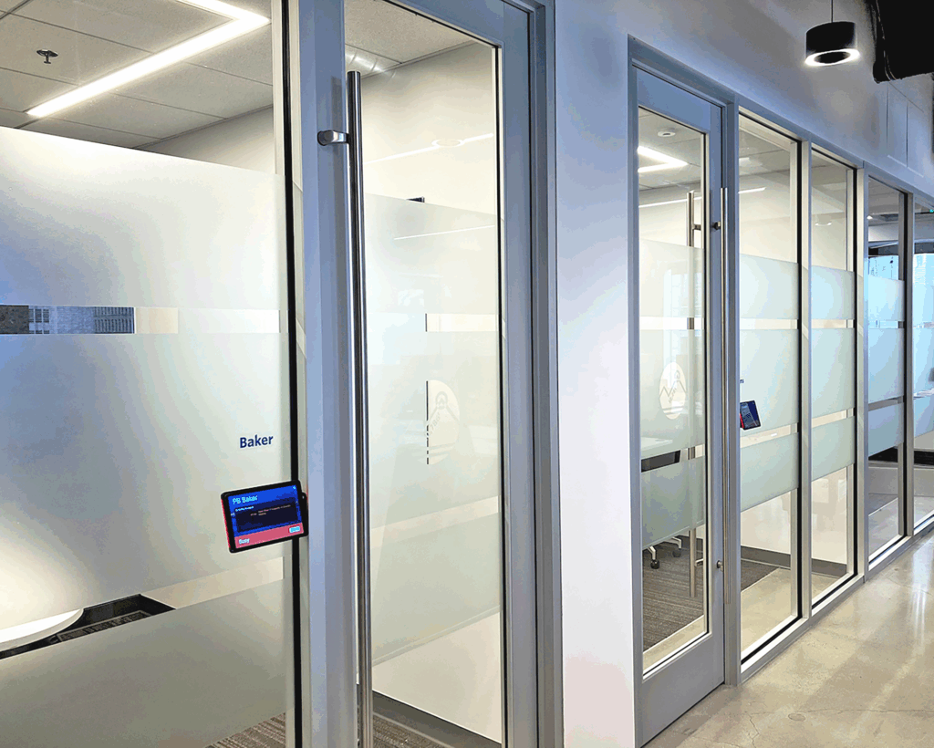 Frosted privacy film applied to glass conference room doors in a corporate office for branding and confidentiality.