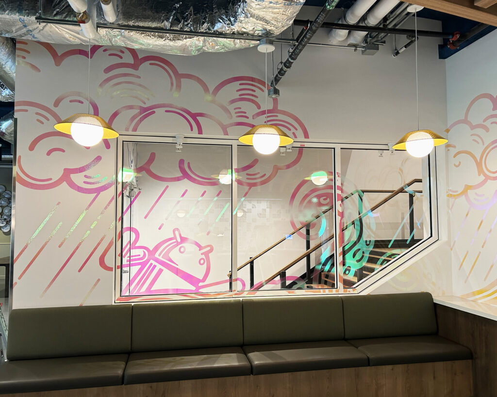 Photo of specialty print materials installed in construction page by SuperGraphics. Showcases reflective printed graphics on wall and window space.