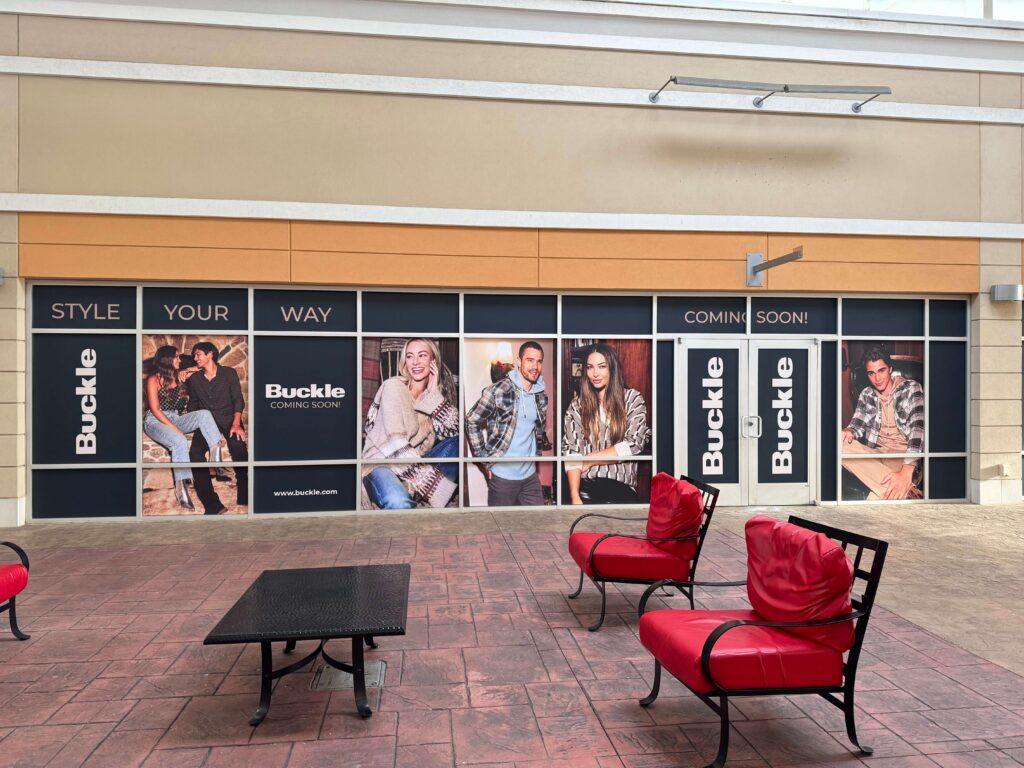 Exterior Buckle storefront wrapped with full-color lifestyle window graphics and “Style Your Way — Coming Soon!” branding, produced and installed by SuperGraphics.