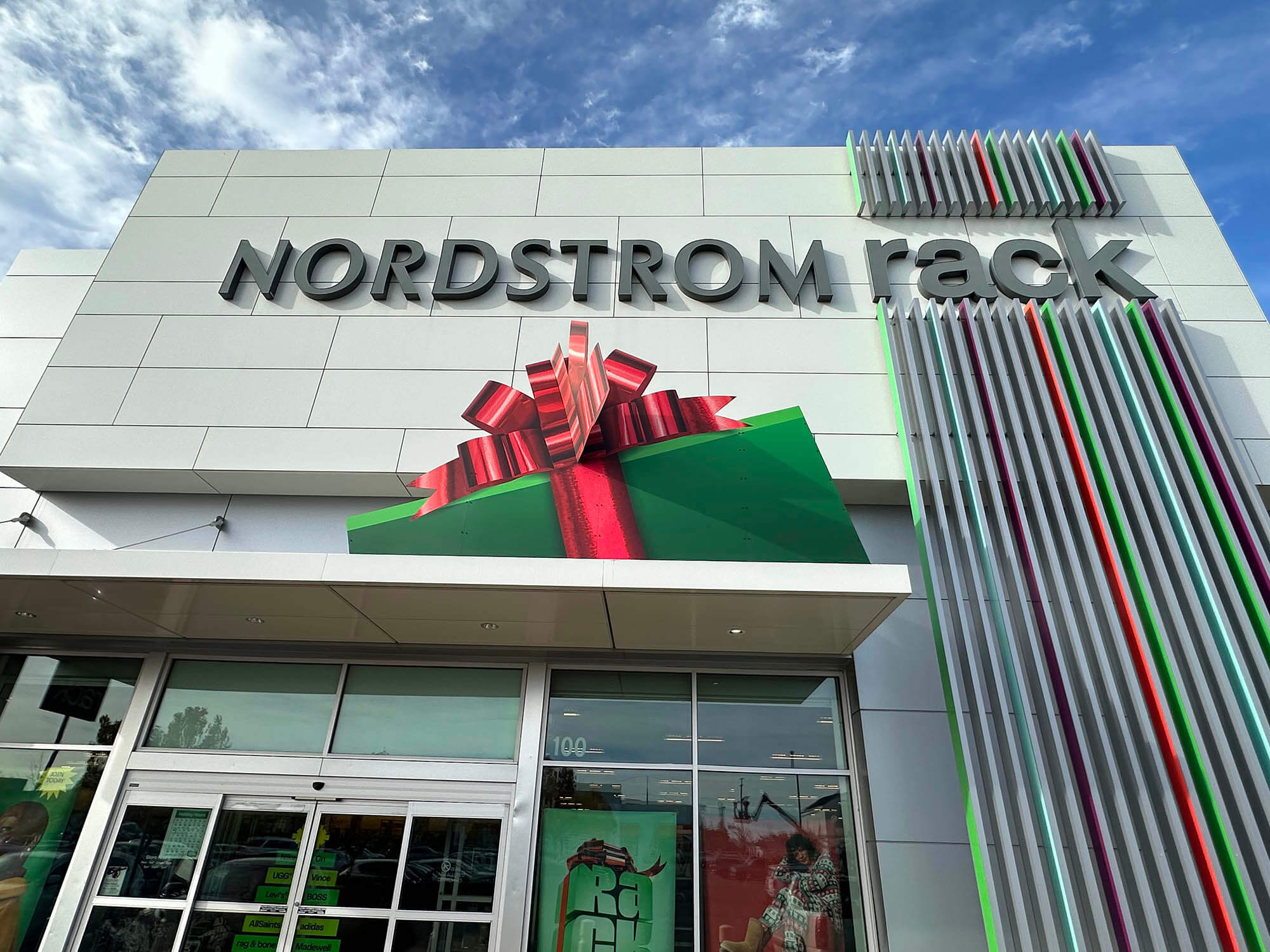 Nordstrom Rack storefront featuring an oversized 3D holiday gift box installation above the entrance, created for the 2025 Holiday campaign by The Imagine Shop by SuperGraphics.