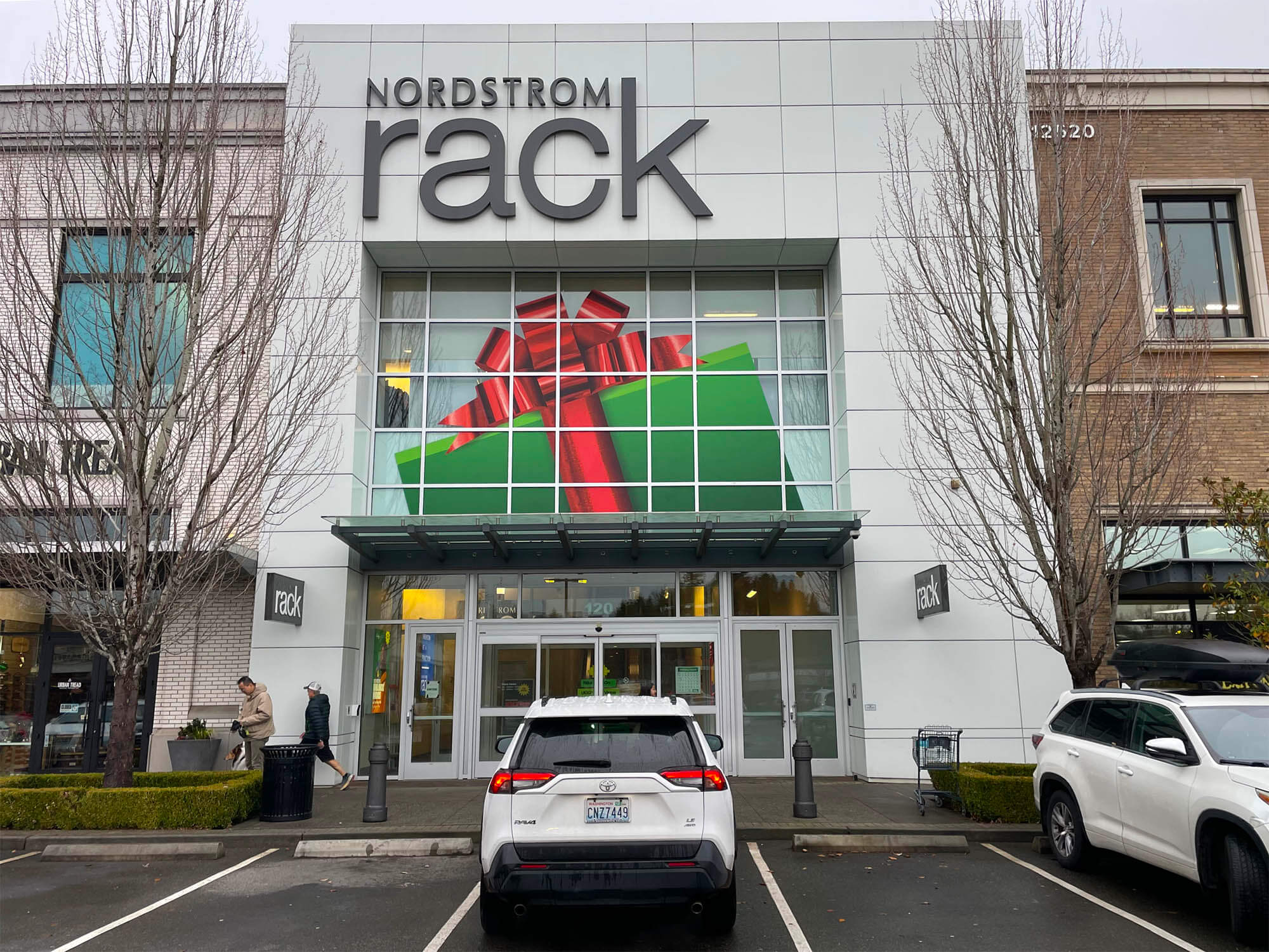 Nordstrom Rack storefront featuring an oversized holiday gift box window graphic above the entrance, produced by The Imagine Shop by SuperGraphics for the 2025 Holiday campaign.