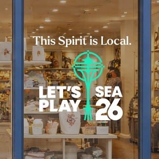 SuperGraphics SEA 26 retail kit window graphic reading "This Spirit is Local" with the Let's Play SEA 26 Space Needle logo, displayed on a retail storefront window.