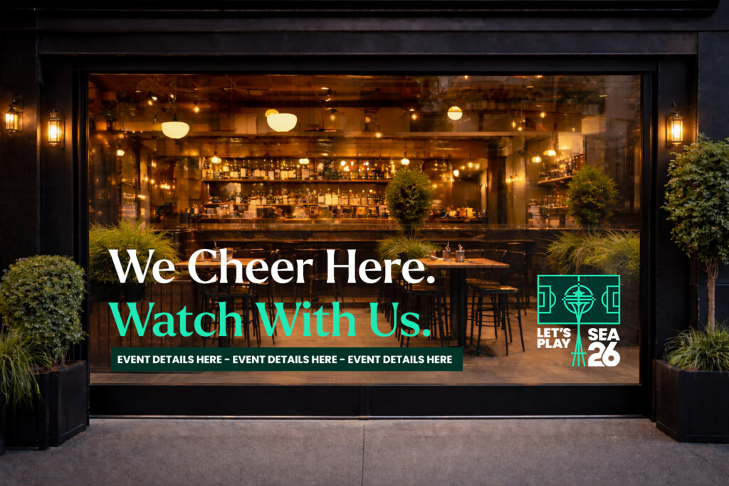 SuperGraphics watch party kit window graphic reading "We Cheer Here. Watch With Us." with Let's Play SEA 26 branding, displayed on a restaurant storefront window.