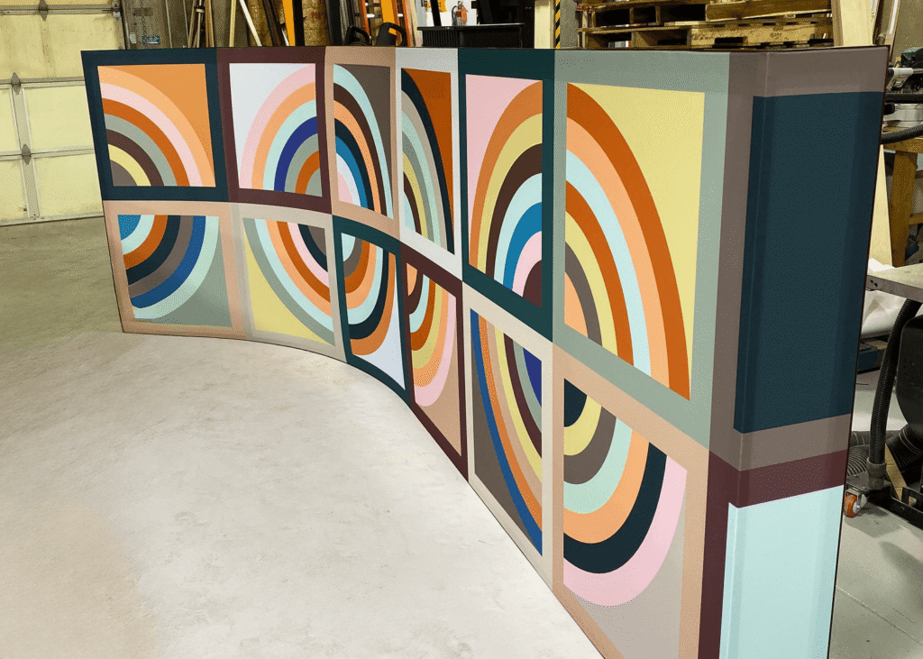 Custom curved fabric display with colorful geometric rainbow arc pattern produced by SuperGraphics