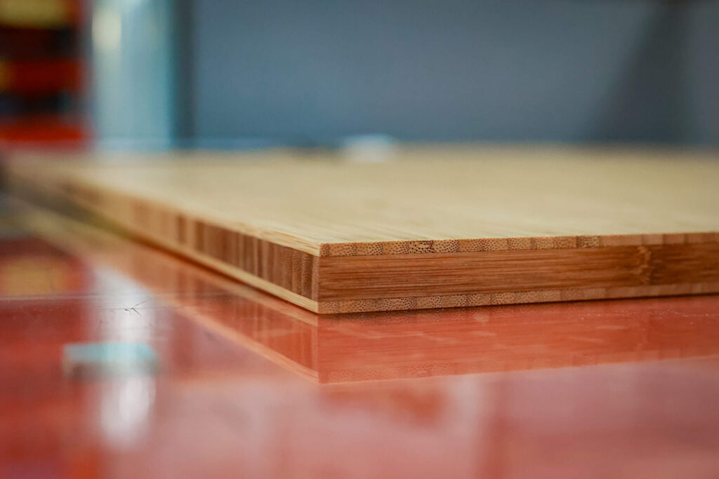 Close-up of a laminated bamboo panel on a red work surface