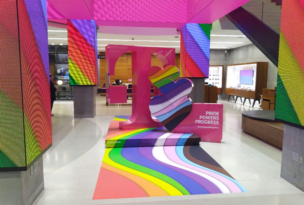 Graphics for T-Mobile Pride campaign 2022, completed by SuperGraphics. Features rainbow window graphics, and rainbow T-Mobile pedestal installation with floor graphics.