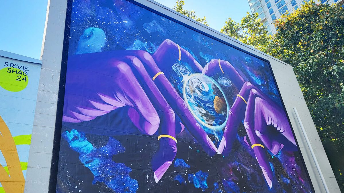 SuperFormat Banner produced and installed by SuperGraphics. Shows large graphic of purple hands creating heart around the earth.