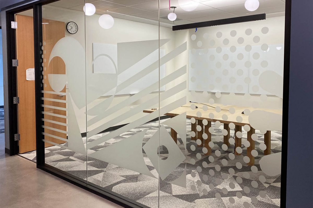 Frosted glass conference room graphics featuring abstract shapes, stripes, and dotted patterns in a modern office setting.