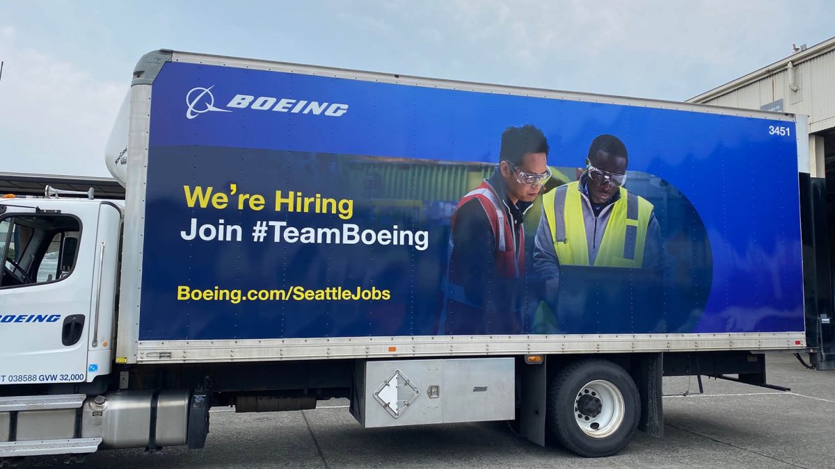 Boeing fleet wrap, produced and installed by SuperGraphics. Showcases branded graphics and photography of team, highlighting brand messaging "We're Hiring, Join Team Boeing."