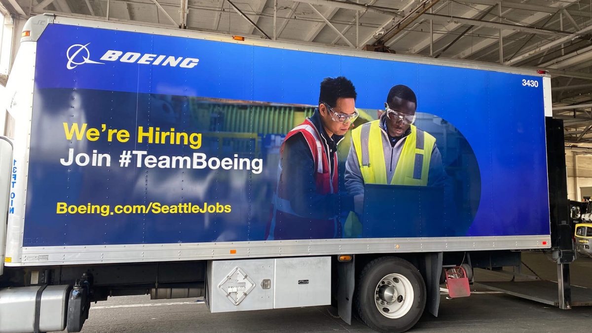 Boeing fleet wrap, produced and installed by SuperGraphics. Showcases branded graphics and photography of team, highlighting brand messaging "We're Hiring, Join Team Boeing."