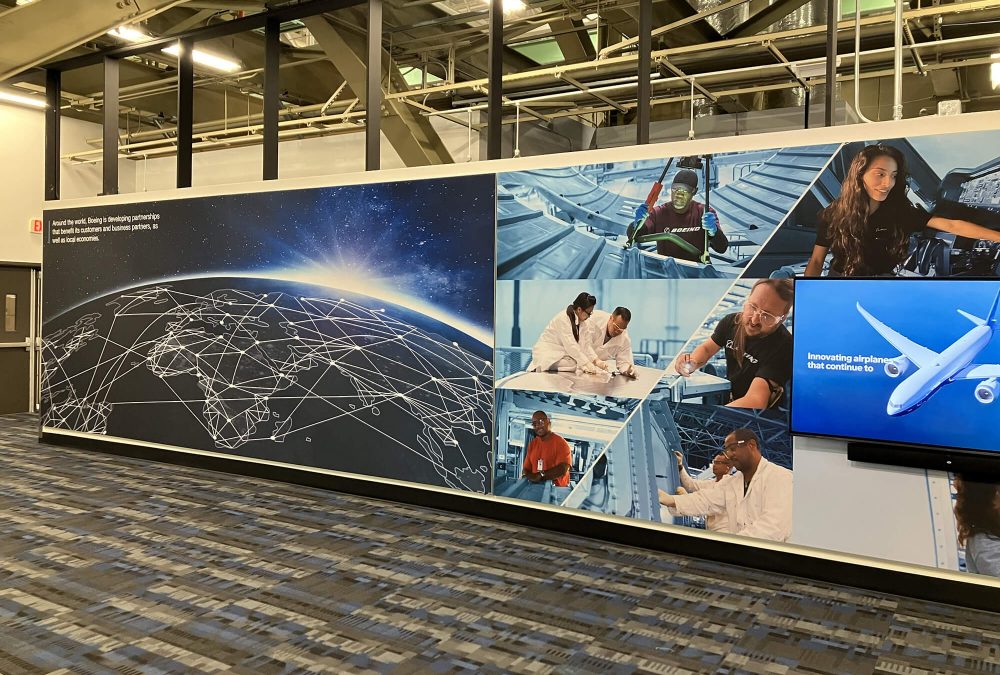 Large-format custom SEG fabric wall display featuring Boeing global partnerships map and employee imagery produced by SuperGraphics