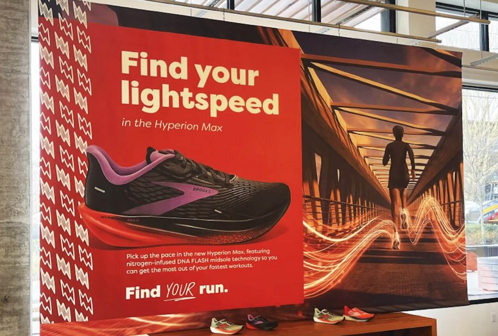 Large custom fabric display promoting the Brooks Hyperion Max running shoe installed in a retail location produced by SuperGraphics