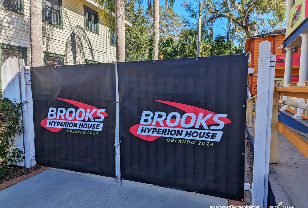 A pair of large black banners with the Brooks Hyperion House logo installed on a fence.
