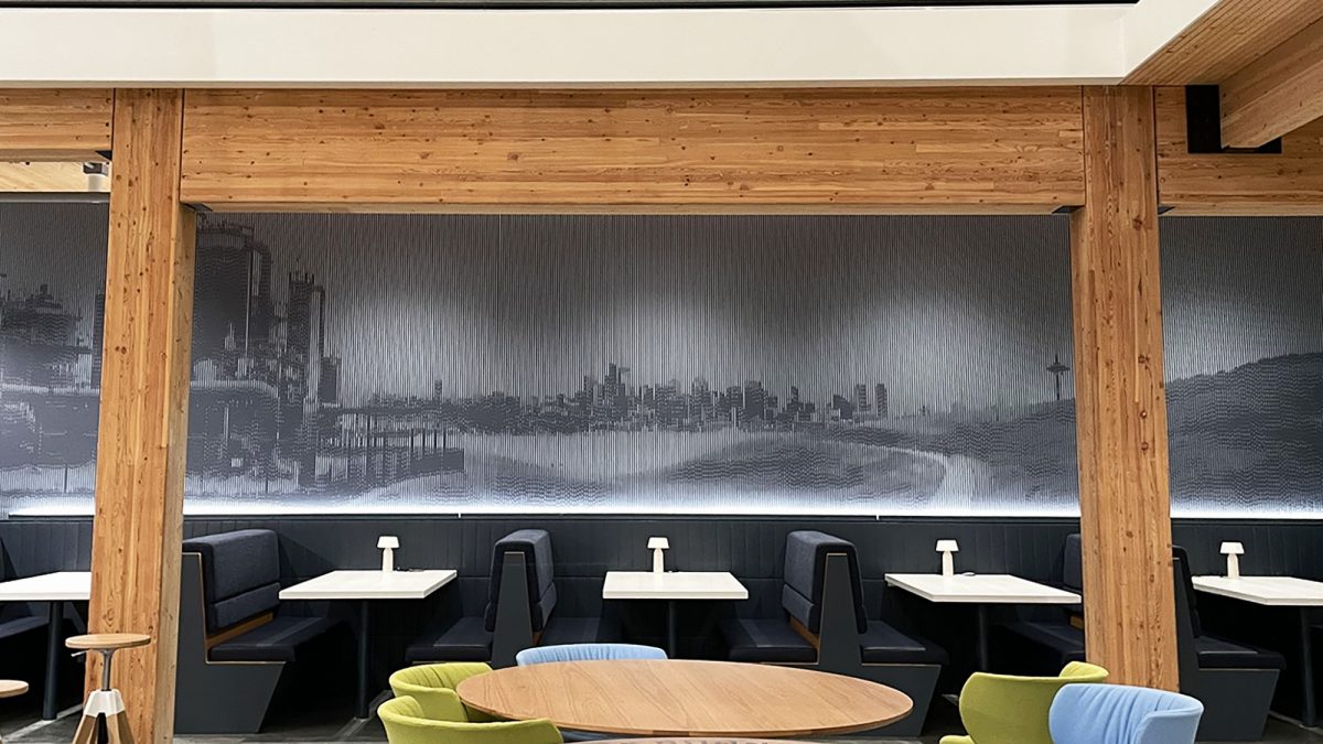 Photo of wall mural installation at Brooks Running, produced and installed by SuperGraphics. Showcases black and white wall mural of Gasworks Park installed on a heavily corrugated wall.