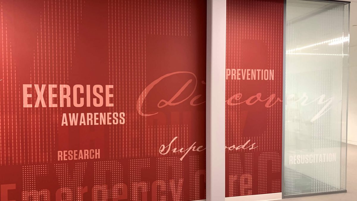 Central Washington University Health Services wall mural, produced and installed by SuperGraphics. Includes brand-related words in cursive on top of red background.