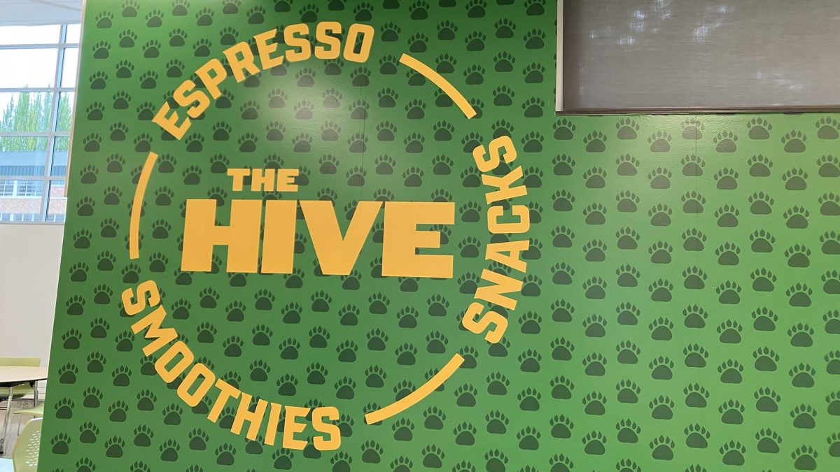 Charles Wright Academy Wall Graphics, produced and installed by SuperGraphics. Showcases logo for The Hive, a student store, on top of green bear paw iconography.