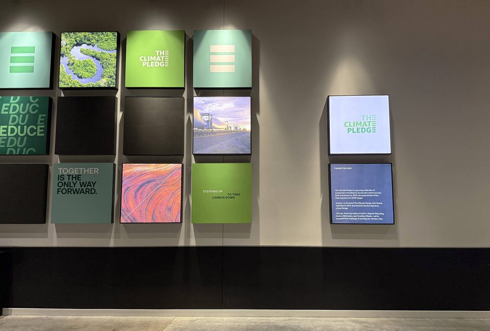 Grid of custom backlit SEG fabric frames displaying The Climate Pledge branding and sustainability messaging at Climate Pledge Arena produced by SuperGraphics