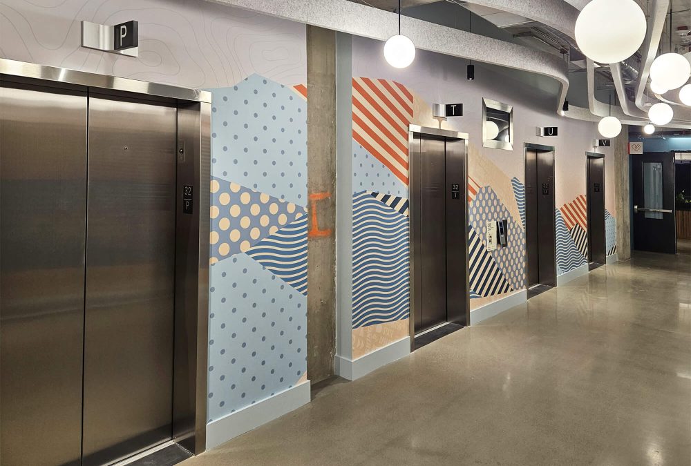 Corporate elevator graphics, produced and installed by SuperGraphics. Showcases playful illustrative design on walls outside of elevator bay.