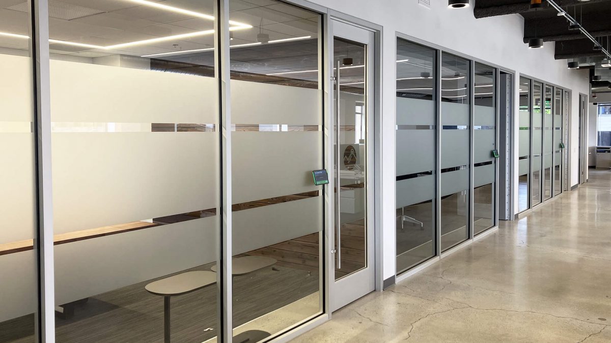 Corporate Privacy Window film, produced and installed by SuperGraphics. Showcases custom designs on dusted crystal window film, on corporate office glass wall.