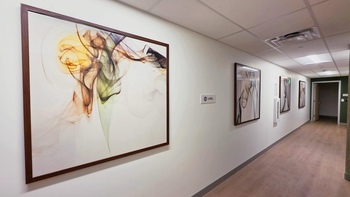 Framed Prints for Evergreen Health, completed by SuperGraphics. Shows uniform watercolor prints extending down hallway.