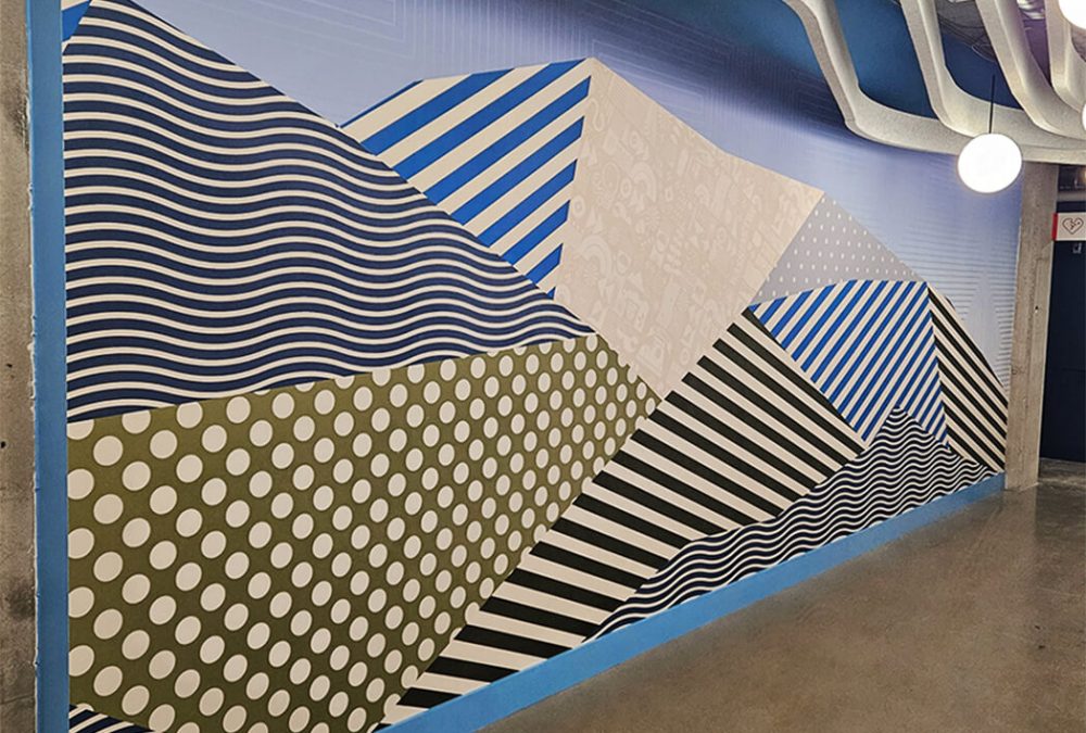 A wall covering featuring abstract blue waves and beige patterns creating a calming office atmosphere.
