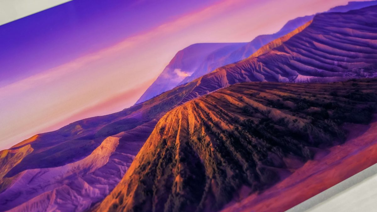 Close up image of fine art print of mountain range with purple hues and horizon.