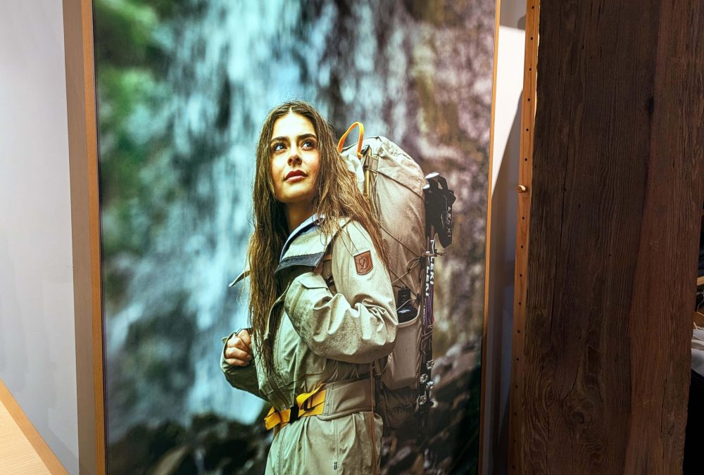 Custom SEG fabric frame with Fjällräven lifestyle hiking imagery in a wood-framed retail display produced by SuperGraphics