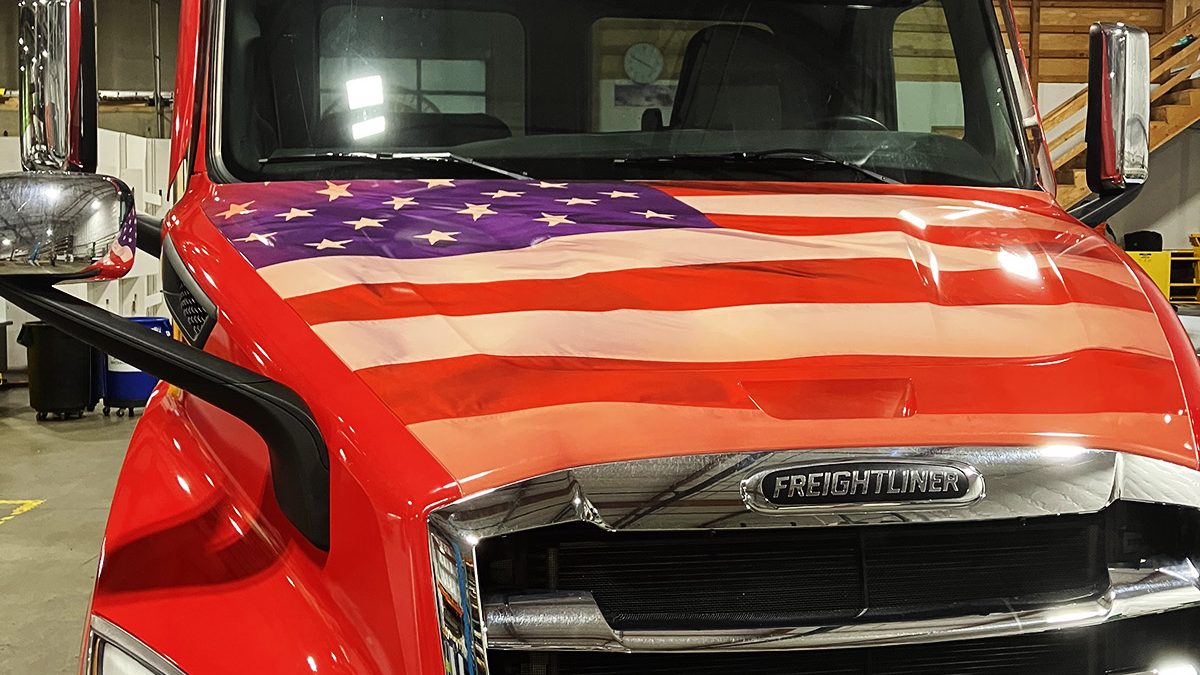 A Darigold semi-truck wrapped with a red American flag graphic and Darigold branding, emphasizing patriotic themes.