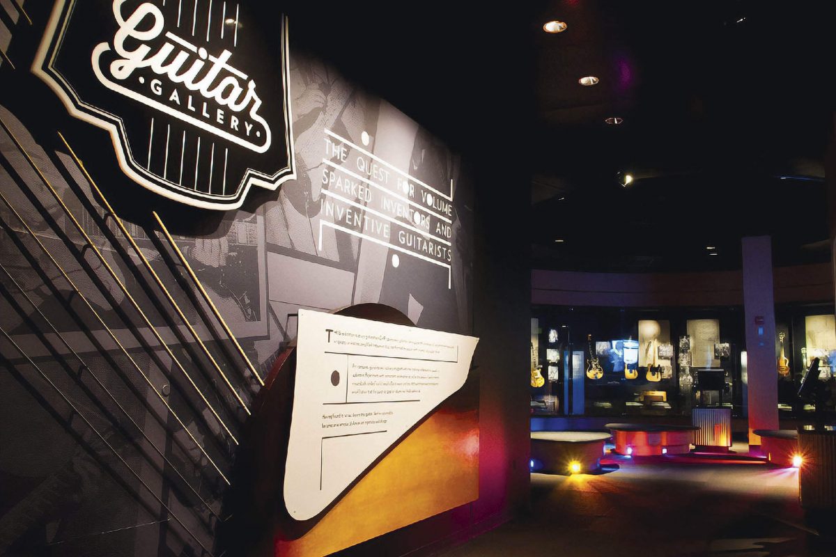 MoPOP Guitar Gallery exhibit entrance featuring illuminated wall graphics, bold typography, and a view into the guitar display gallery, produced and installed by SuperGraphics.