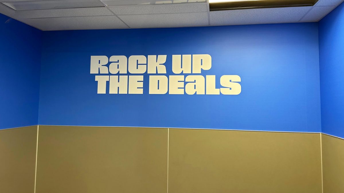 Nordstrom Rack wall mural, produced and installed by SuperGraphics. Graphic says 'Rack up the deals' in fitting room area.