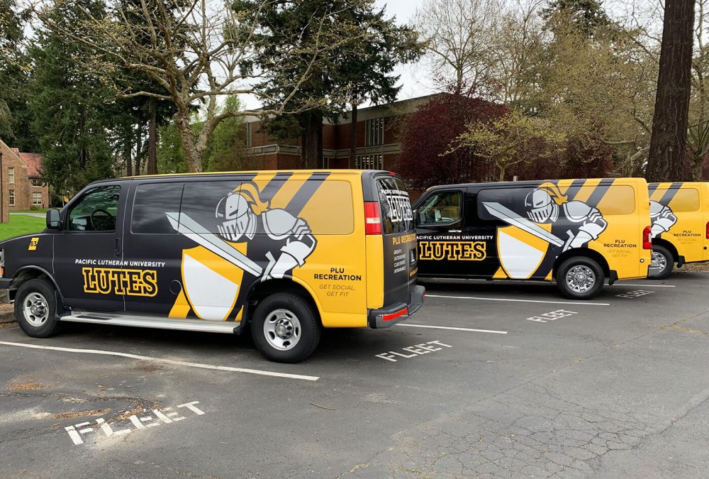 Pacific Lutheran University's service vehicle fleet wrap, produced and installed by SuperGraphics. Showcases brand logos and PLU mascot atop black and white graphics.