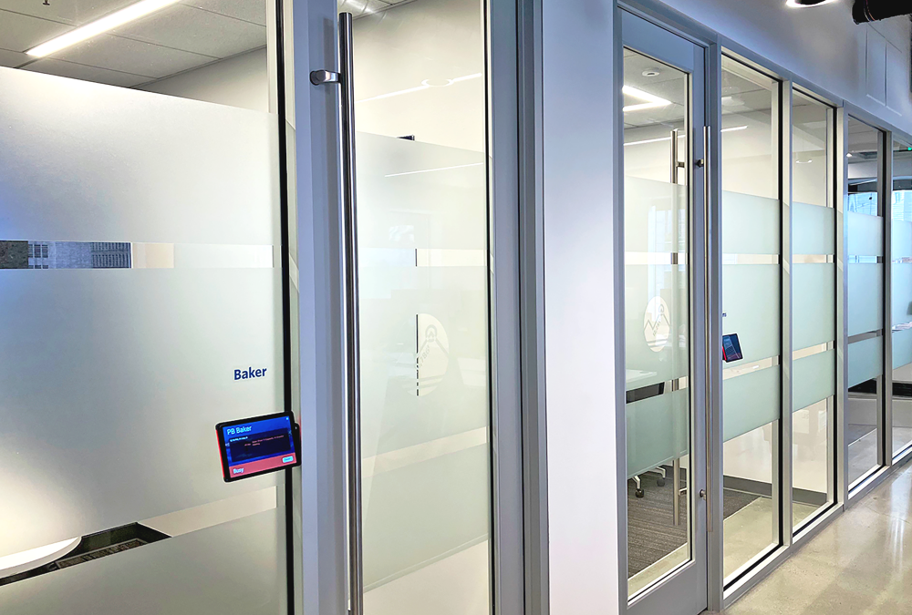 Frosted privacy film applied to glass conference room doors in a corporate office for branding and confidentiality.