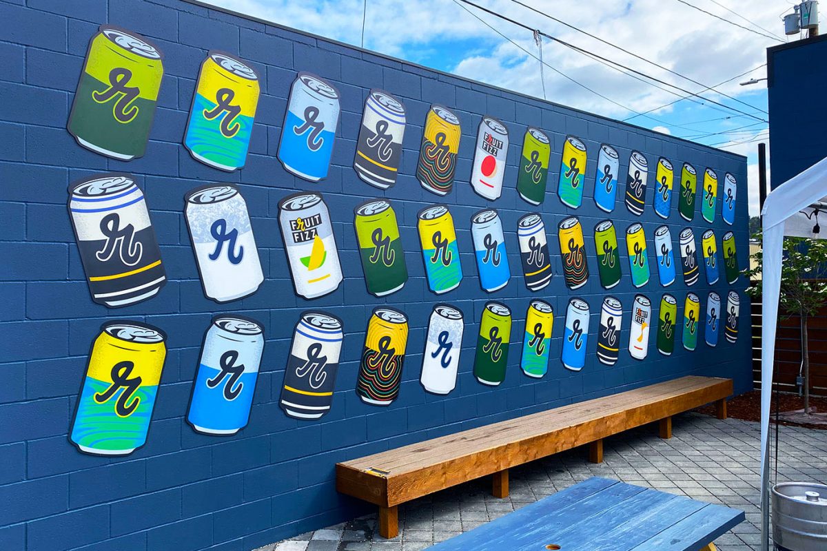 Reuben's Brewery dimensional signage, produced and installed by SuperGraphics. Showcases cider cans dimensional signage on patio space.