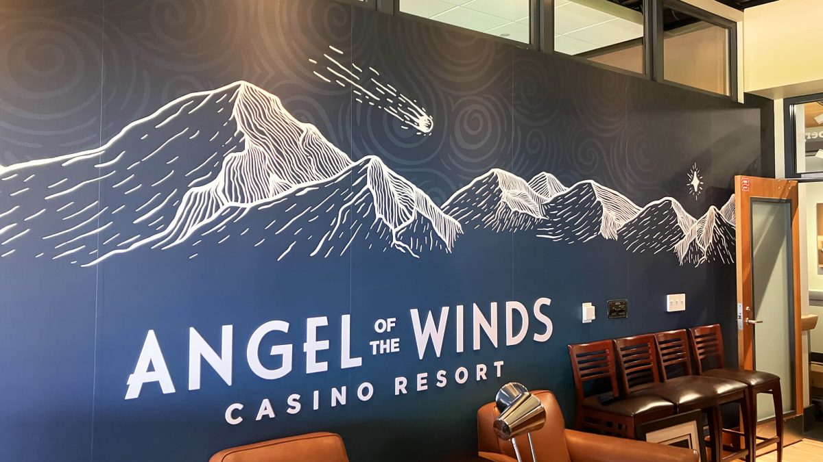 Seattle Seahawks wall mural for Angel of the Winds suite, produced and installed by SuperGraphics. Showcases sponsorship branding and mountain illustration.