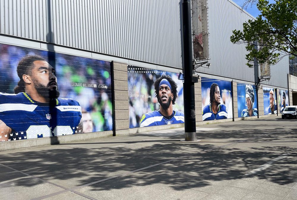 Seattle Seahawks exterior tall mural, produced and installed by SuperGraphics. Includes headshots of various Seahawks players on outside of Lumen Field.