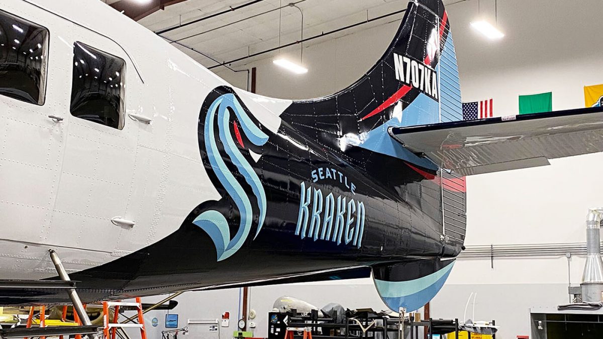 Seattle Kraken plane wrap, produced and installed by SuperGraphics. Showcases Kraken logos and branded stripes on back of plane.