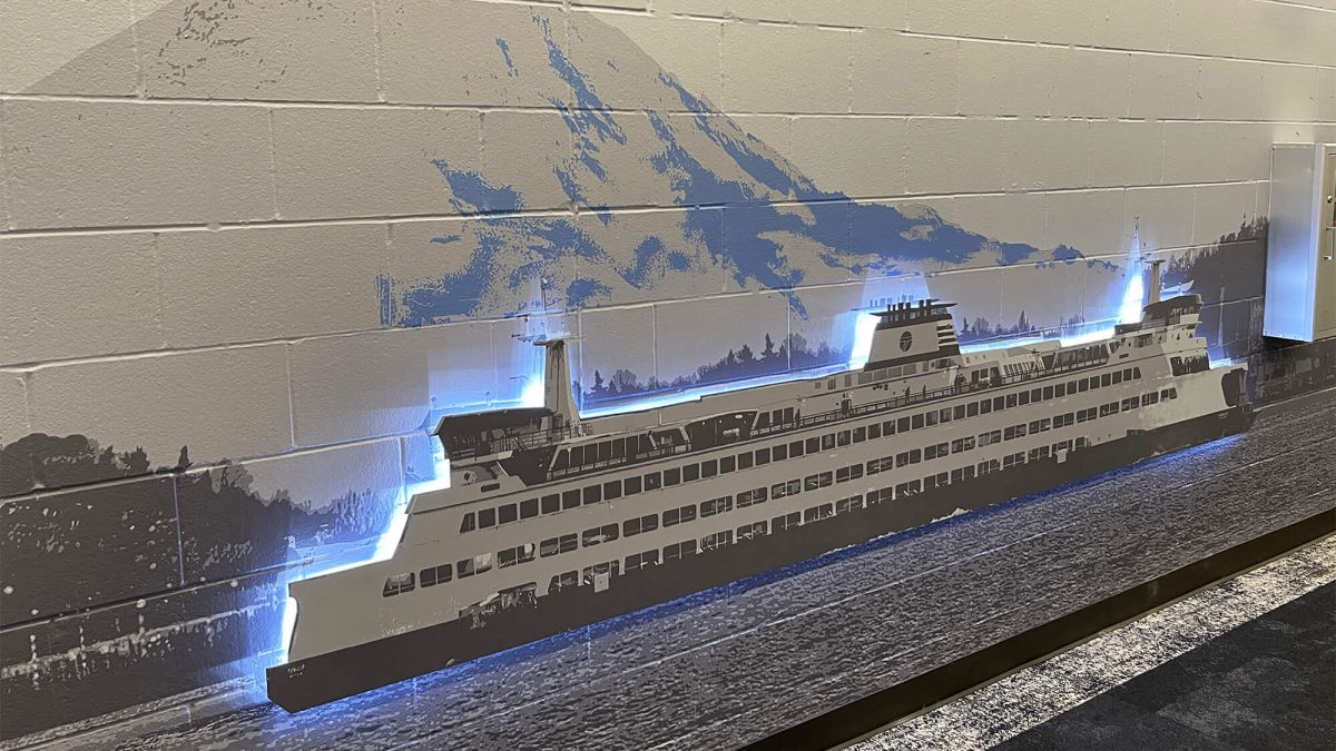 Wall mural for Mariners Training Facility, showcasing Seattle cityscape. Produced and installed by SuperGraphics. Showcases dimensional and illuminated ferry boat protruding off wall.