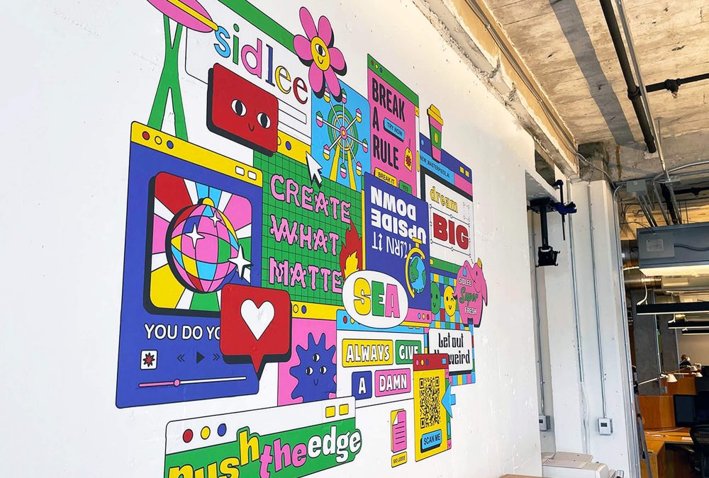 Wall graphic for Sid Lee corporate office, produced and installed by SuperGraphics. Showcases colorful branded illustrations woven into various Sid Lee brand messaging.