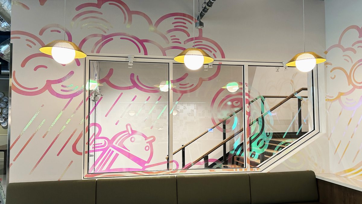 Photo of specialty print materials installed in construction page by SuperGraphics. Showcases reflective printed graphics on wall and window space.