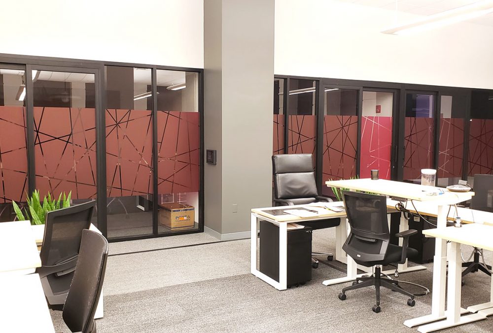 Privacy film window graphics for T-Mobile call center, produced and installed by SuperGraphics. Showcases magenta window graphics on conference room windows, printed with T-Mobile's magenta pink and cutout pattern design.