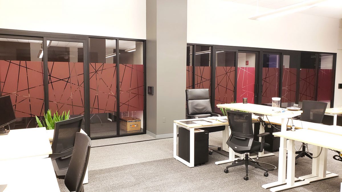 Privacy film window graphics for T-Mobile call center, produced and installed by SuperGraphics. Showcases magenta window graphics on conference room windows, printed with T-Mobile's magenta pink and cutout pattern design.