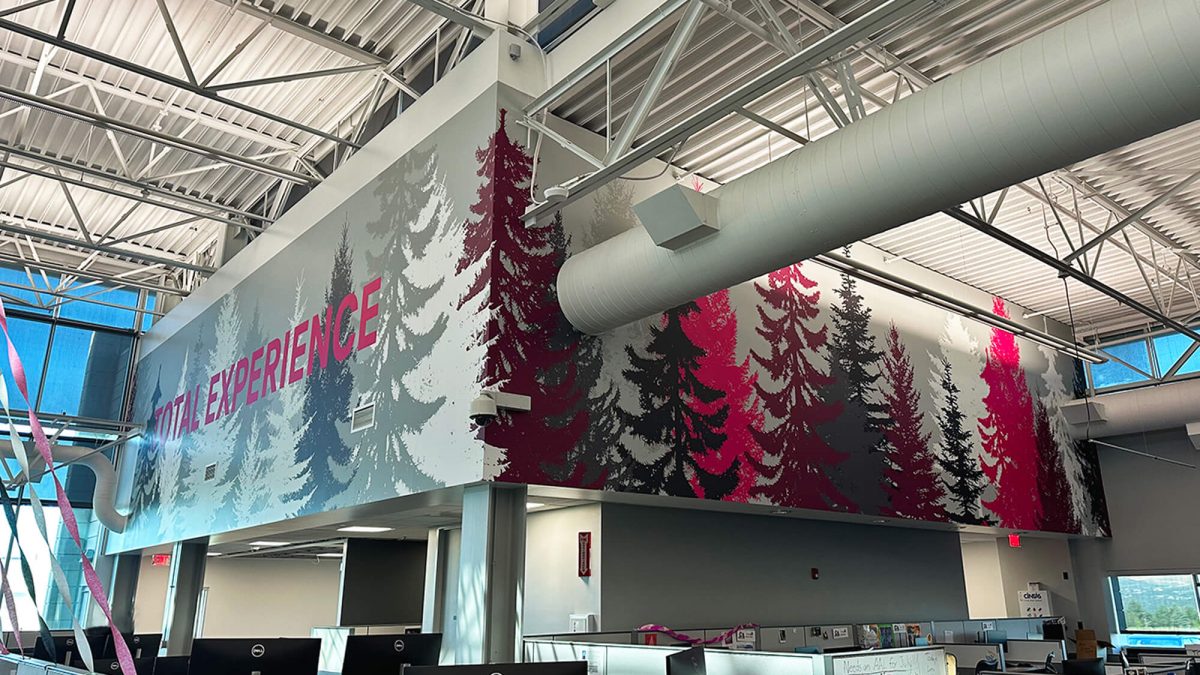 T-Mobile corporate office wall graphic, produced and installed by SuperGraphics. Showcases evergreen trees in brand colors on high office wall.