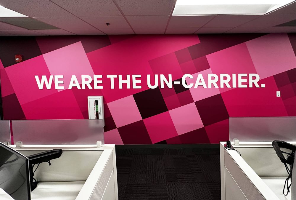 Corporate office wall graphic, produced and installed by SuperGraphics. Showcases T-Mobile's pink branding and the message: "We are the Un-Carrier."
