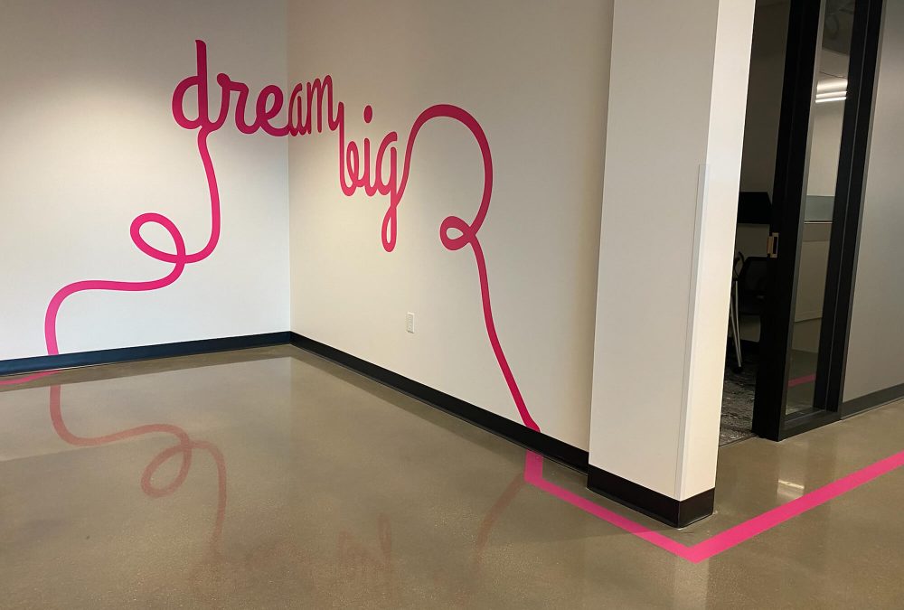 T-Mobile corporate office wall graphics, produced and installed by SuperGraphics. Showcases the message "dream big" in curly writing style, also extending off the wall and turning into a floor graphic.