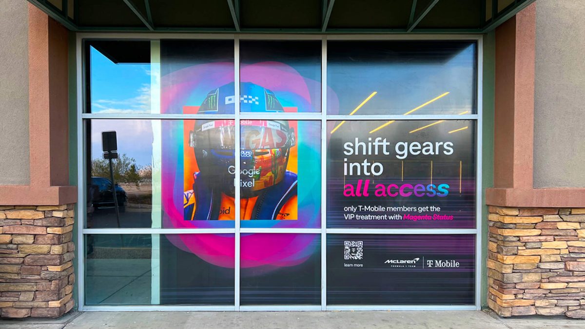 Storefront window graphics for T-Mobile and F1 collaboration. Showcases colorful graphics of F1 driver on front of T-Mobile store.